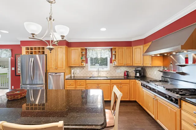 a kitchen with stainless steel appliances granite countertop a stove a sink and a refrigerator