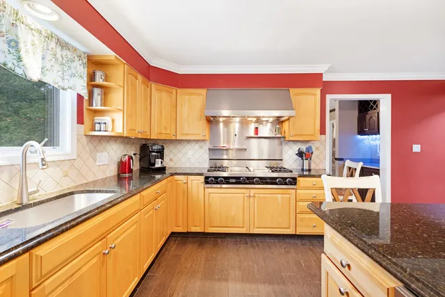 a kitchen with stainless steel appliances granite countertop a stove a sink and a microwave