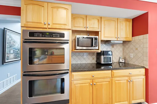 a kitchen with granite countertop cabinets stainless steel appliances and a sink