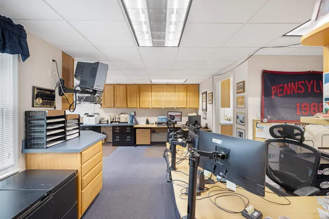 a living room with furniture a flat screen tv and kitchen view