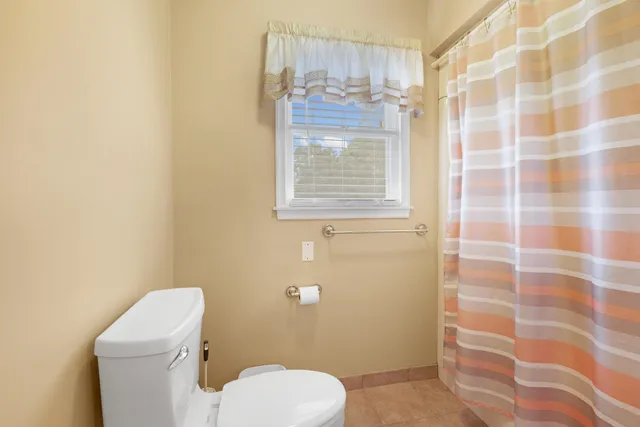 a white toilet sitting next to a shower curtain
