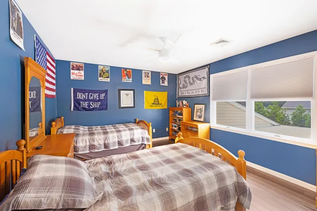 a bedroom with a bed and dresser next to a large window