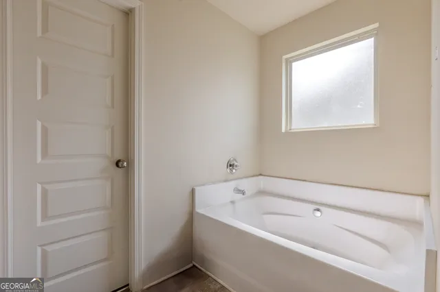 a bathroom with a bathtub and window