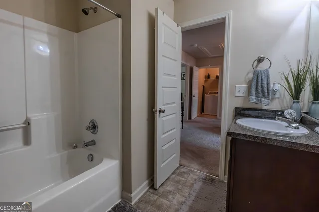 a bathroom with a tub sink and mirror