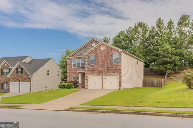 a front view of a house with a garden and garage