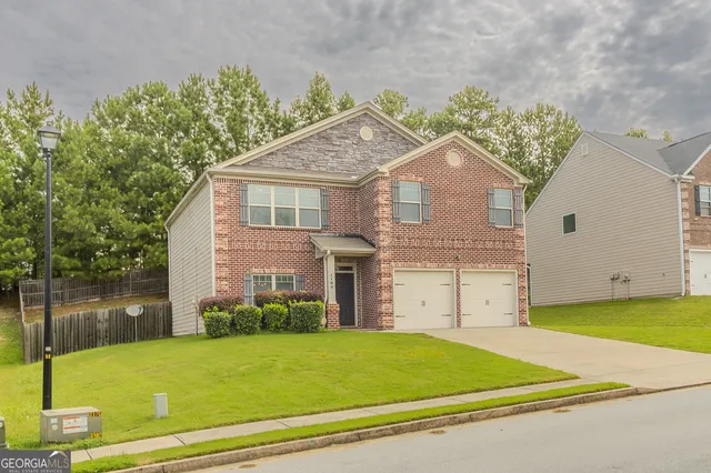 a view of a house with a backyard and a tree