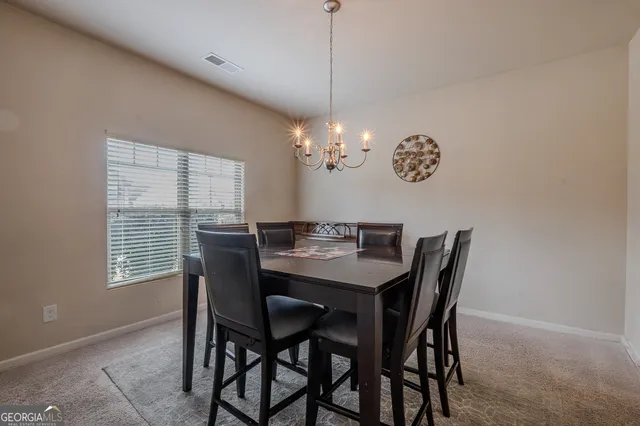 a dining room with furniture a chandelier and window