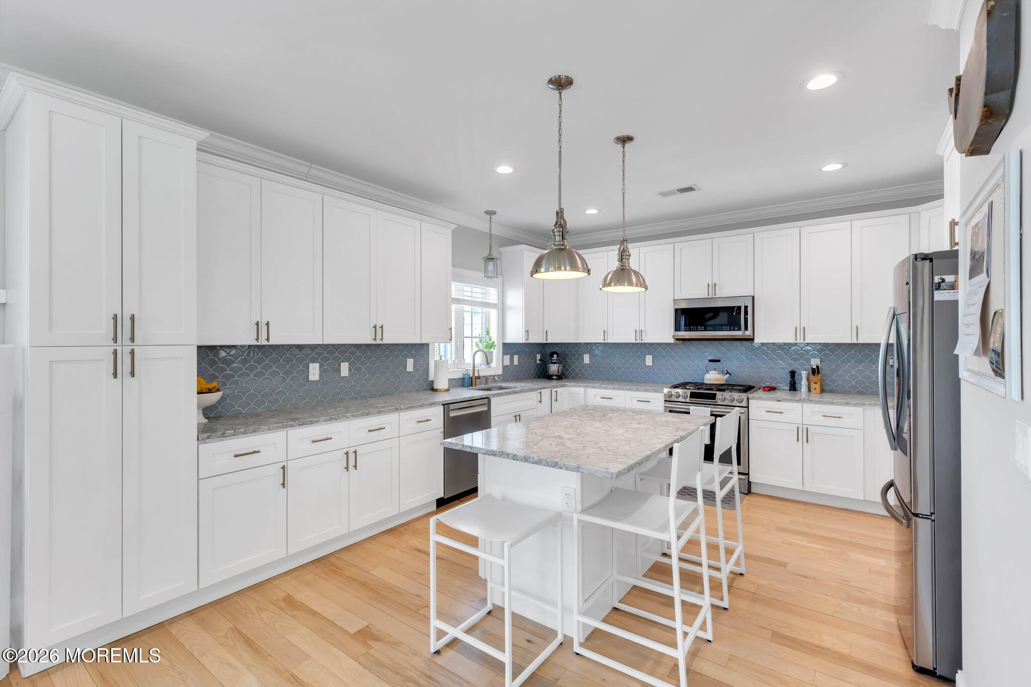 12 4th Street Highlands, NJ 07732 - Photo 14 of 41 a kitchen with white cabinets and stainless steel appliances