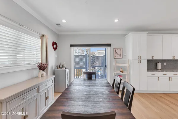 an open kitchen with granite countertop kitchen island white cabinets and wooden floor