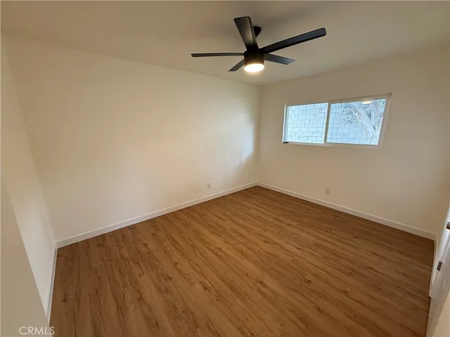 an empty room with a window and a ceiling fan