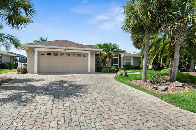 a front view of a house with a yard and potted plants