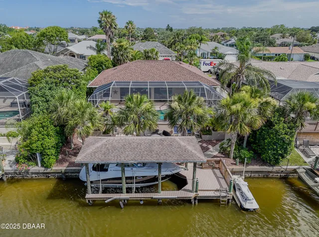 a view of a patio with table and chairs potted plants and floor to ceiling window