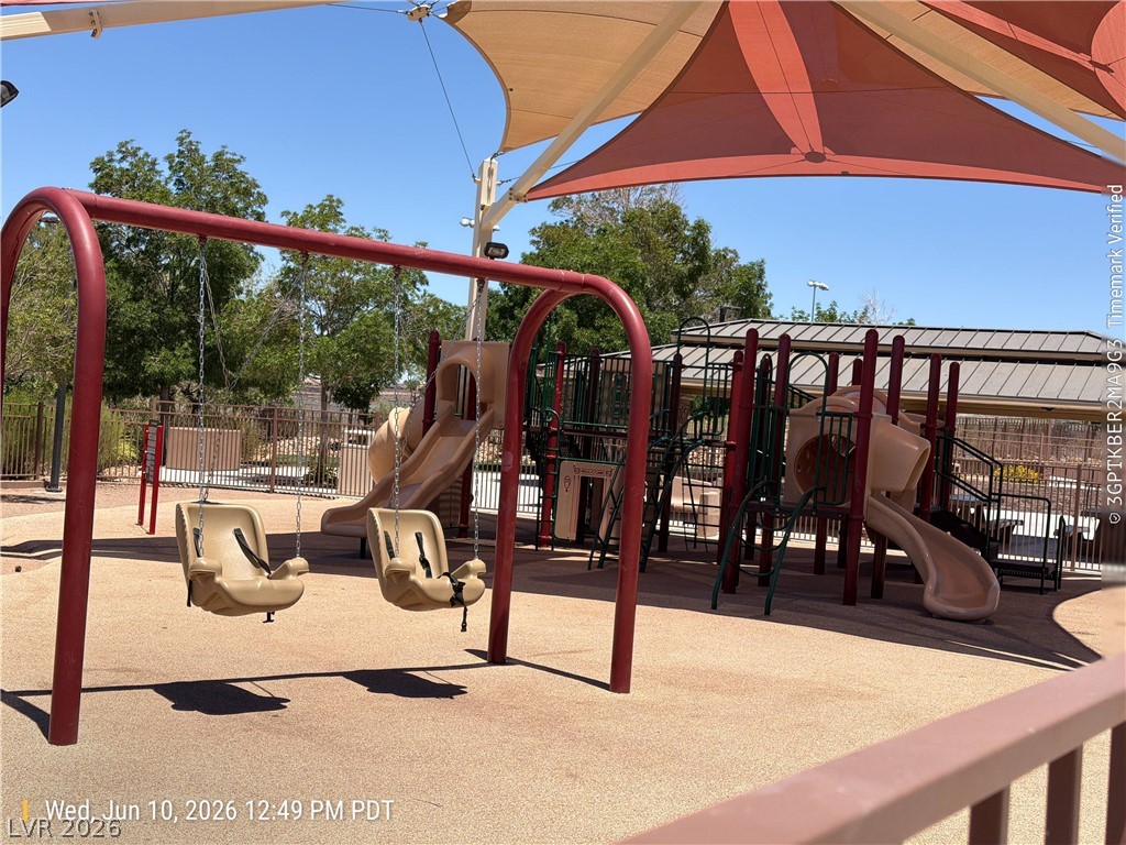 2388 Rue Bienville Way Henderson, NV 89044 - Photo 16 of 16 A vibrant playground area offers swings and slides under protective shade canopies, perfect for family enjoyment.