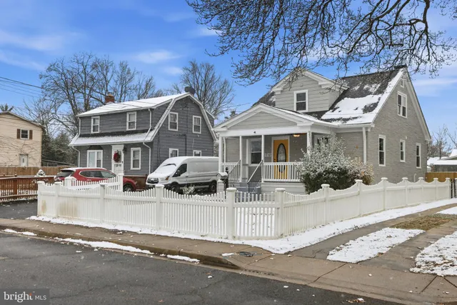 a view of a white house with large windows and a table and chairs