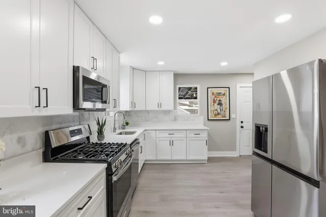 a kitchen with stainless steel appliances a refrigerator stove and sink