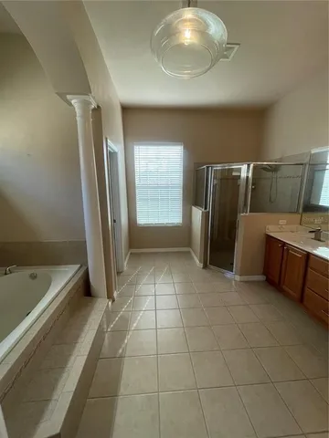 a bathroom with a tub a mirror and a shower