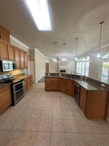 a large kitchen with granite countertop a stove a sink dishwasher and a refrigerator
