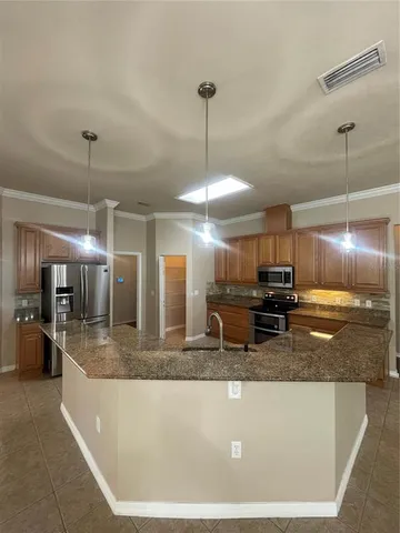 a large kitchen with granite countertop a sink and a stove top oven with granite countertops