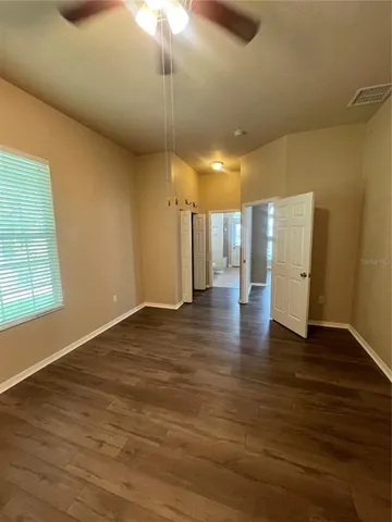 an empty room with wooden floor and window
