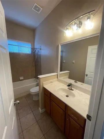 a bathroom with a sink a toilet a mirror and shower