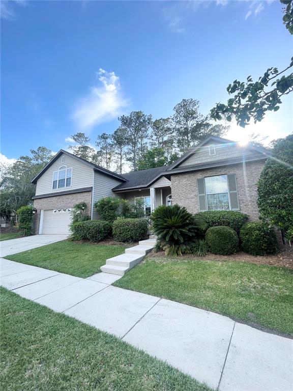 2244 Northwest 101st Street Gainesville, FL 32606 - Photo 3 of 39 a view of a big house with a big yard and potted plants