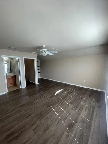 an empty room with wooden floor and fireplace