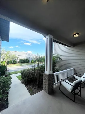 a view of a patio with a table chairs and a floor to ceiling window