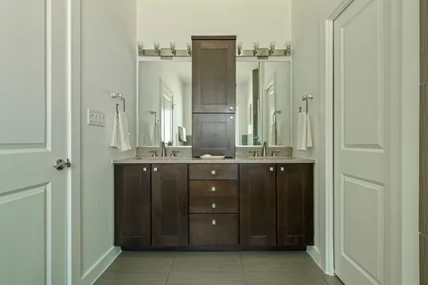 a bathroom with a granite countertop sink a mirror and a shower