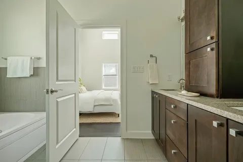 a bathroom with a tub sink and mirror