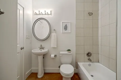 a bathroom with a toilet sink a mirror and tub
