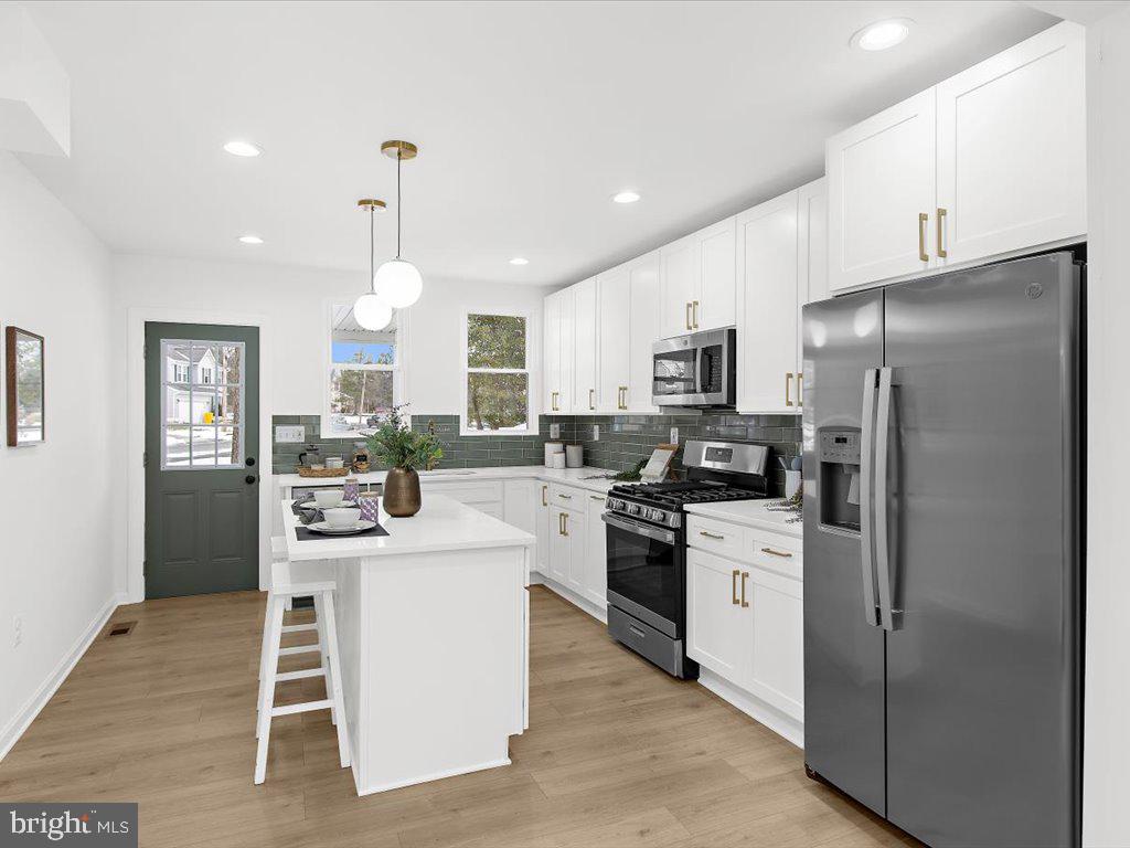 313 North Hammonds Ferry Road Linthicum Heights, MD 21090 - Photo 15 of 39 a kitchen with white cabinets and stainless steel appliances