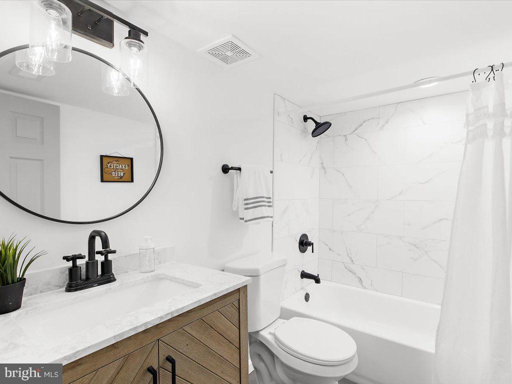 313 North Hammonds Ferry Road Linthicum Heights, MD 21090 - Photo 33 of 39 a bathroom with a sink a toilet a mirror and shower