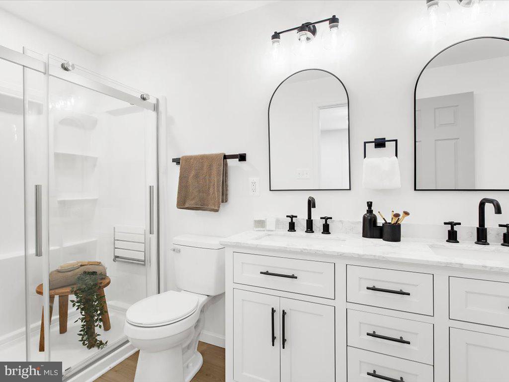 313 North Hammonds Ferry Road Linthicum Heights, MD 21090 - Photo 7 of 39 a bathroom with a toilet sink and mirror