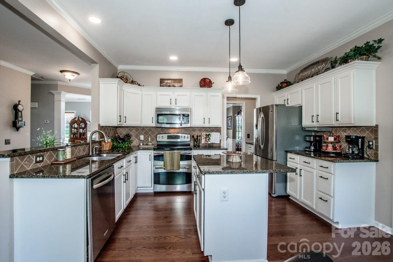 150 Coronilla Road Mooresville, NC 28117 - Photo 15 of 39 a kitchen with stainless steel appliances and white cabinets