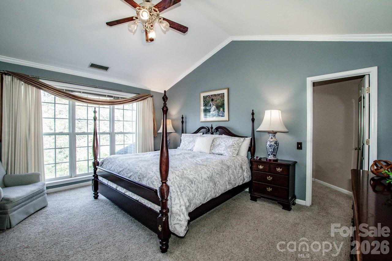 150 Coronilla Road Mooresville, NC 28117 - Photo 18 of 39 a spacious bedroom with a bed and a chandelier