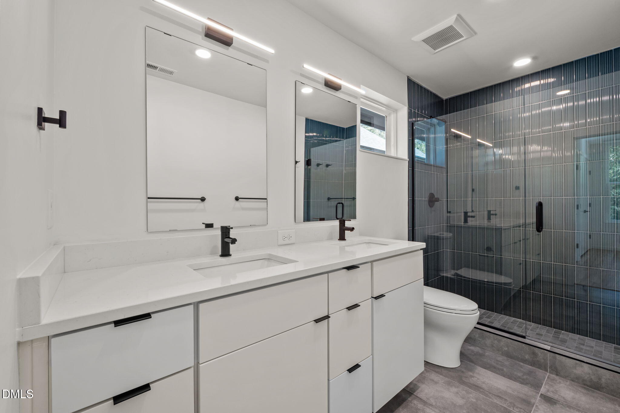 1605 Glendale Avenue Durham, NC 27701 - Photo 32 of 41 a bathroom with a double vanity sink toilet mirror and shower