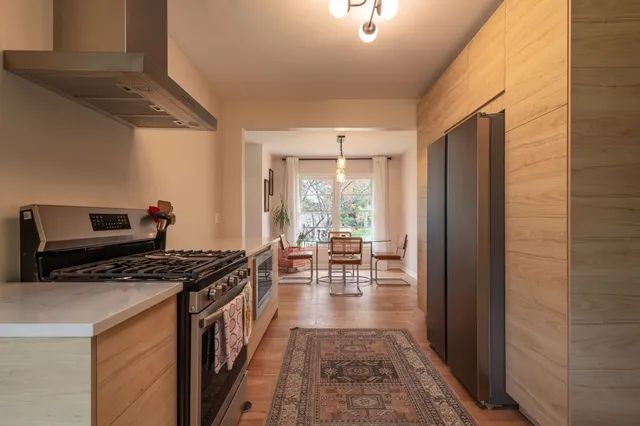 a kitchen with granite countertop a stove a sink and a refrigerator