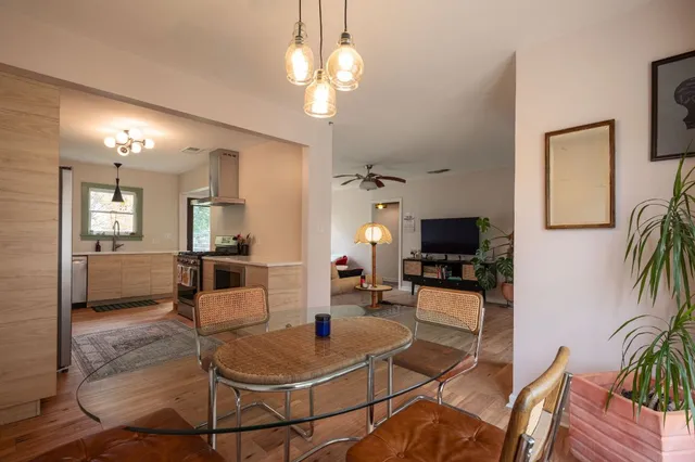 a living room with furniture a flat screen tv and kitchen view