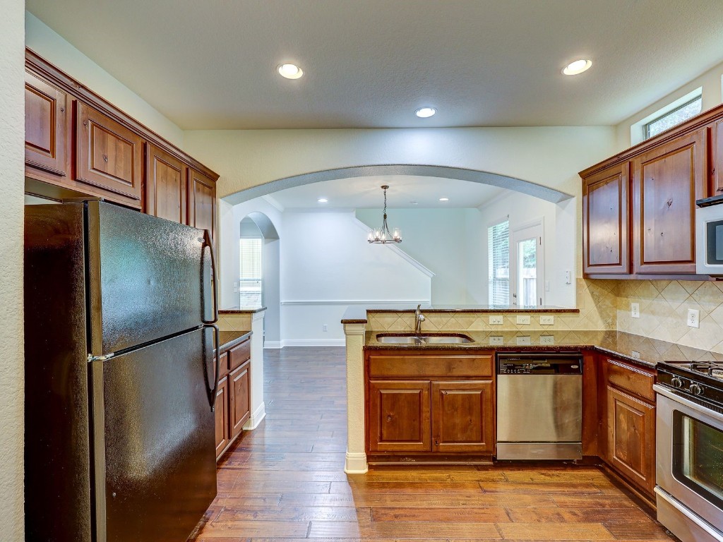 6708 Menchaca Road, Unit 7 Austin, TX 78745 - Photo 13 of 32 a kitchen with stainless steel appliances granite countertop a refrigerator and a stove