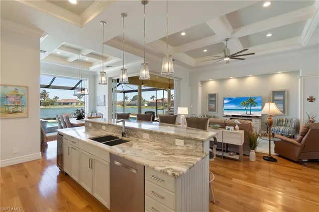 a kitchen with stainless steel appliances granite countertop a lot of cabinets and couches with wooden floor