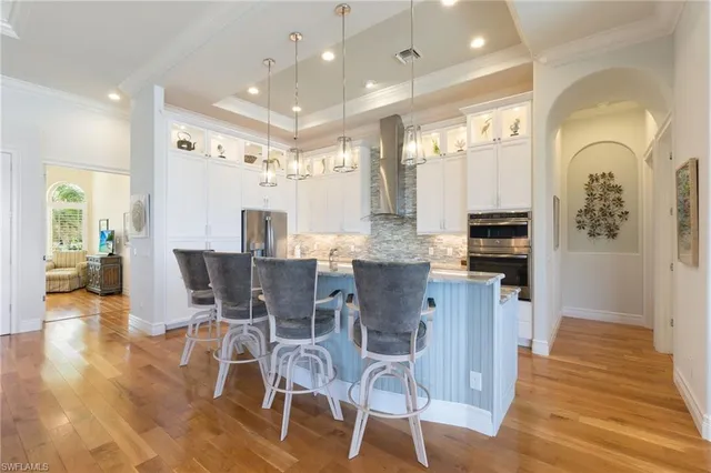 a dining room with stainless steel appliances kitchen island granite countertop a table and chairs in it
