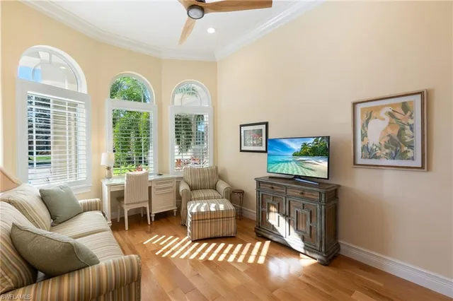 a living room with furniture a flat screen tv and a large window