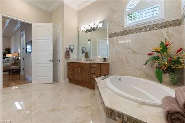 a spacious bathroom with a tub sink and mirror