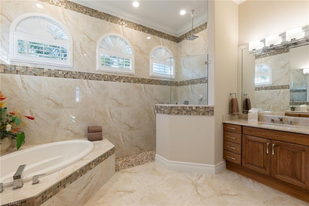 18018 Broadview Drive Naples, FL 34114 - Photo 21 of 46 a spacious bathroom with a tub sink and mirror