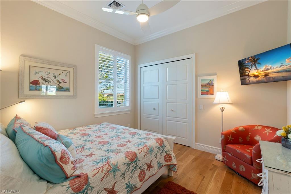 18018 Broadview Drive Naples, FL 34114 - Photo 23 of 46 a bedroom with a bed and wooden floor
