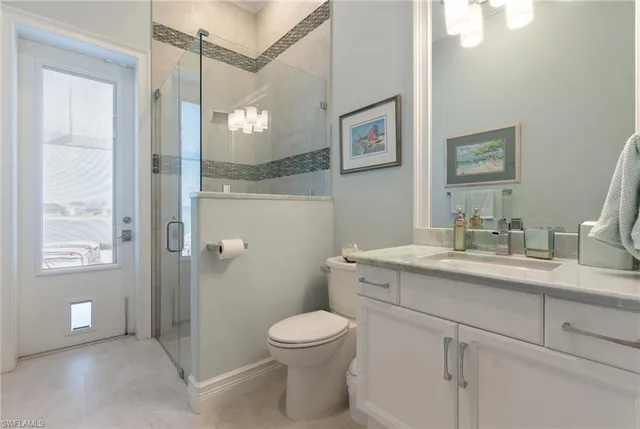 a bathroom with a toilet a sink a mirror a vanity and shower