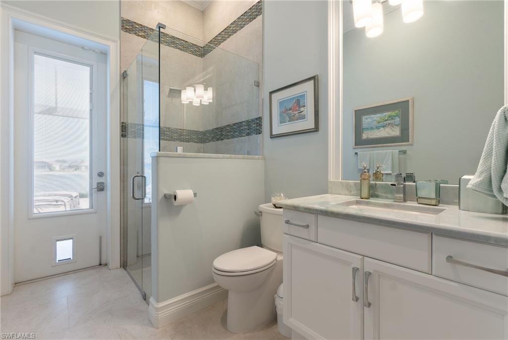 18018 Broadview Drive Naples, FL 34114 - Photo 26 of 46 a bathroom with a toilet a sink a mirror a vanity and shower