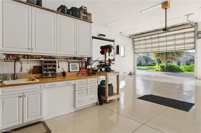 a kitchen with white cabinets and window
