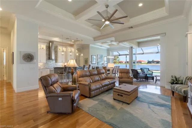 a living room with furniture kitchen view and a large window