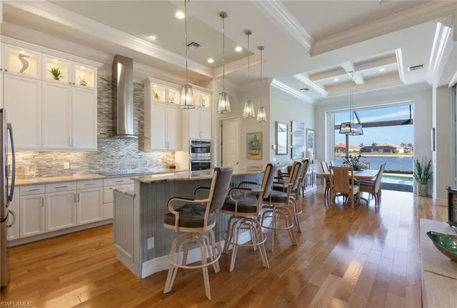 a kitchen with a dining table chairs and view living room